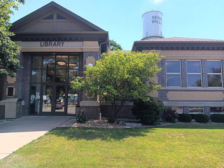 Richard A. Mautino Library's front door. The library is a brick Carnegie building and you can see the Spring Valley water tower behind it.